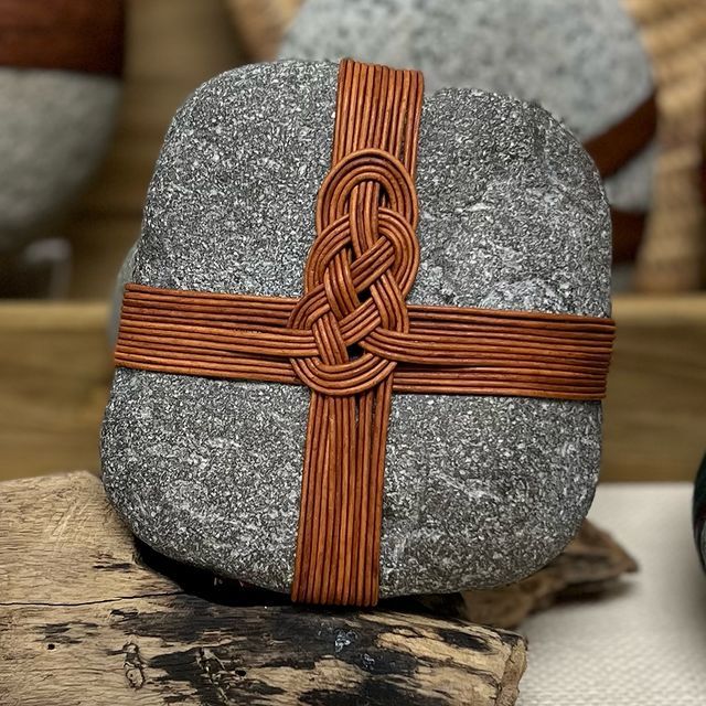 a rock with a cross on it sitting next to a vase