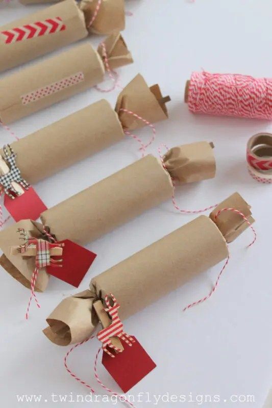 several rolls of brown paper with red and white twine tied to them on a table