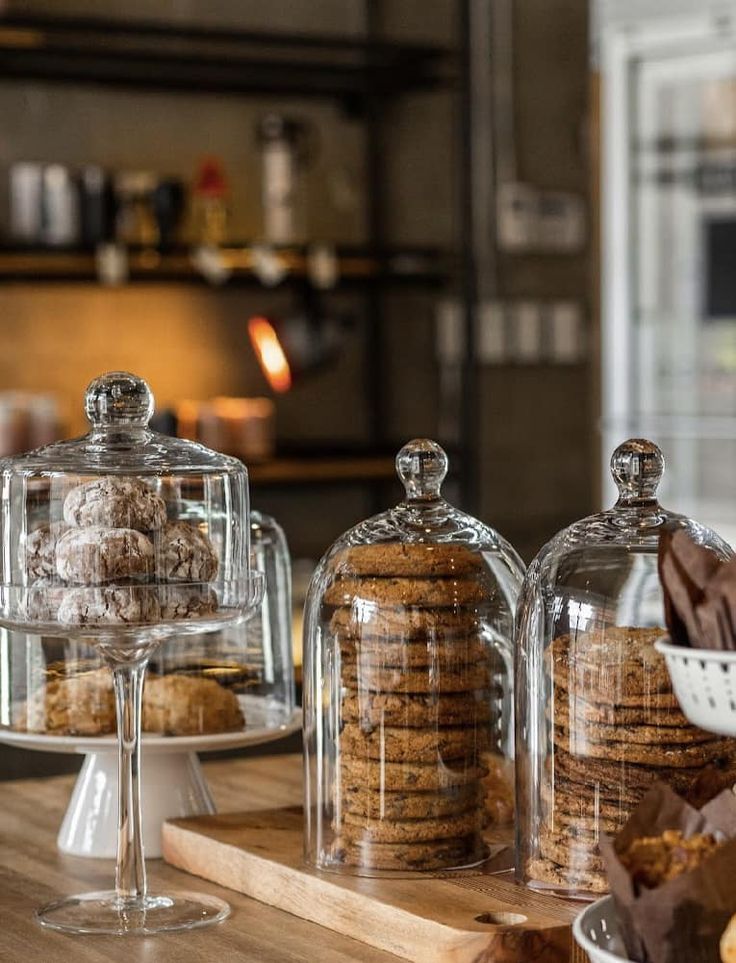 some cookies and pastries are under glass domes