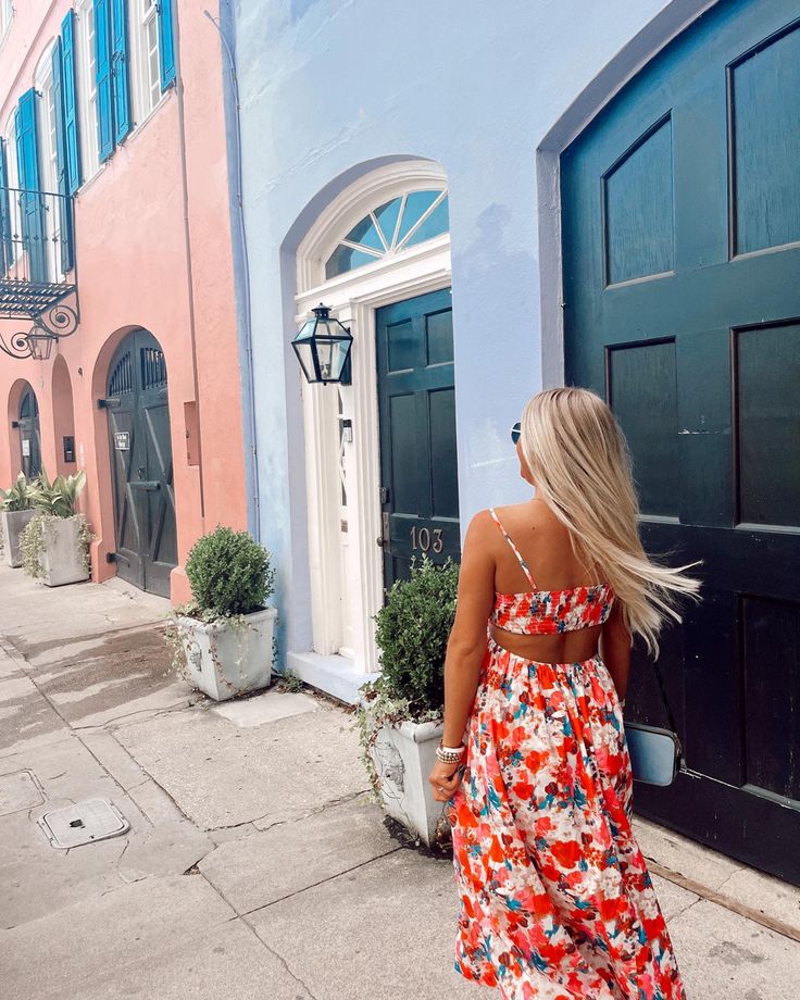 a woman in a floral dress walking down the street