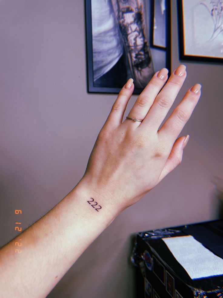 a woman's hand with a small tattoo on it