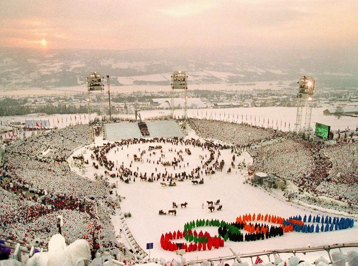 an aerial view of a snow covered stadium with many people standing in the stands and onlookers