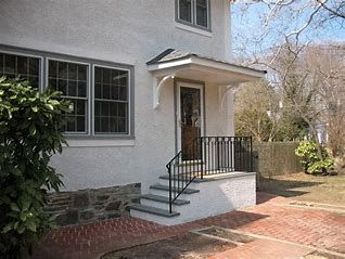 a white house with black railing and windows