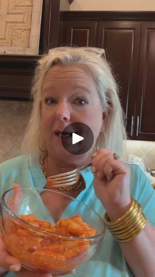 a woman holding a glass bowl filled with food