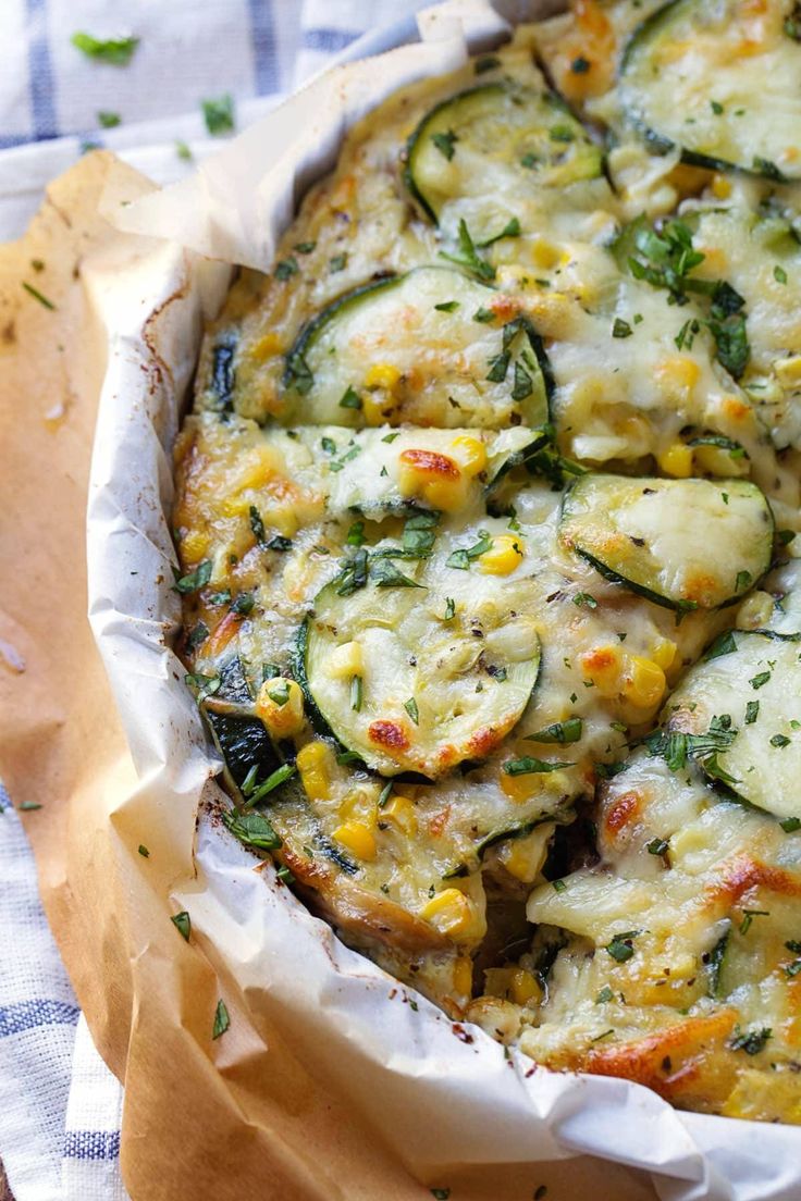 a casserole dish with zucchini, corn and cheese in it on a table