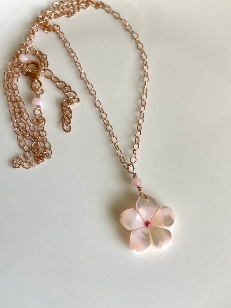 "The cutest little sakura blossom - pink mother of pearl affixed with a tiny pink tourmaline center - is suspended with rose gold-filled wire and dangles from a rose gold-filled cable chain.  Tiny pink opal rondelles frame the wire-wrapping, at the pendant and trigger clasp; necklace measures 17.5\" with a 2\" extender, please select for different length.  Choose between 14K rose gold-filled, sterling silver, or 14K yellow gold-filled metal. Your jewelry will come gift-boxed, and gift-wrapping i Delicate Rose Gold Jewelry With Flower Charm, Delicate Pink Gold Pendant Jewelry, Dainty Pink Gold Flower Jewelry, Elegant Rose Gold Pink Opal Jewelry, Dainty Rose Quartz Jewelry In Rose Gold, Rose Gold Pink Opal Jewelry Gift, Delicate Flower Shaped Pink Gold Jewelry, Delicate Pink Gold Flower Jewelry, Handmade Feminine Rose Gold Jewelry