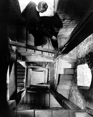 an old black and white photo of a man climbing up stairs