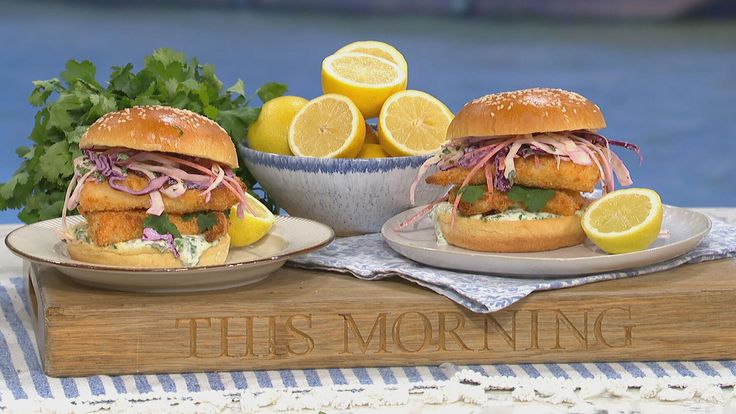 two sandwiches on plates with lemons and parsley next to the plate that says, there's morning