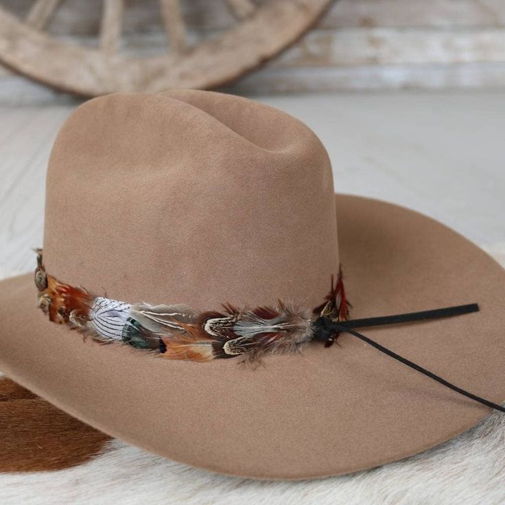 The Vistoso Western Feather Hat Band, with a 3 cm width and approximately 58 cm in length (not including leather ties), offers both versatility and style. This one-size-fits-most accessory is adjustable with leather ties, allowing for a comfortable and secure fit. The feather detailing adds a vibrant touch, making it a standout piece that effortlessly enhances any hat with a hint of western charm. Adjustable Fedora For Fall Rodeo, Adjustable Fall Fedora For Rodeo, Adjustable Fedora For Rodeo In Fall, Adjustable Leather Fedora, Western Adjustable Hats For Fall, Adjustable Western Hat Bands For Fall, Adjustable Hat Bands For Country Events In Fall, Adjustable Country Hat Bands For Fall, Adjustable Hats For Ranch And Fall