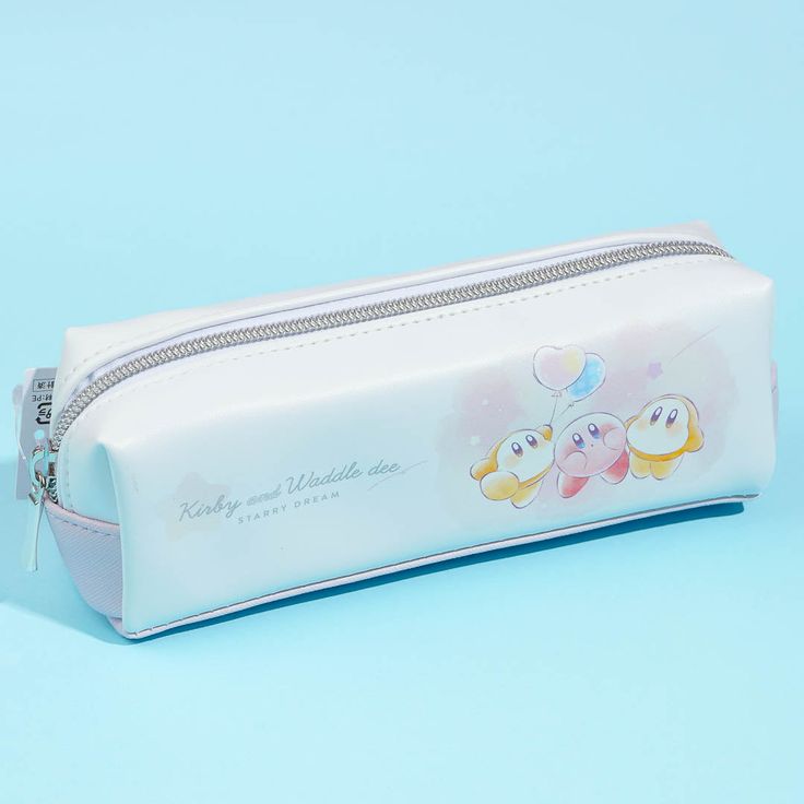 a white pencil case with embellishments on the front and bottom, sitting on a blue background