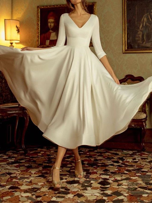 a woman in a white dress is posing for the camera