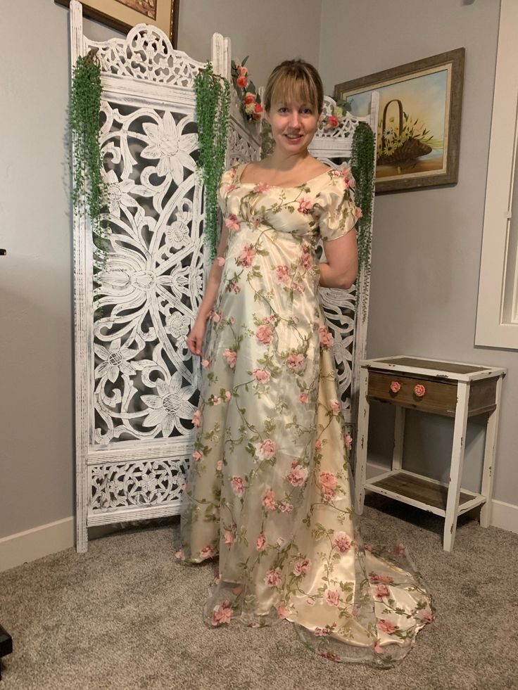 a woman in a floral dress standing next to an ornate white paneled screen door