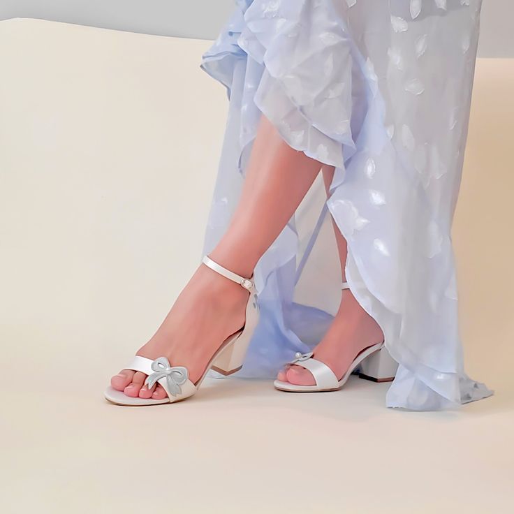 a woman's feet wearing white shoes and a blue dress