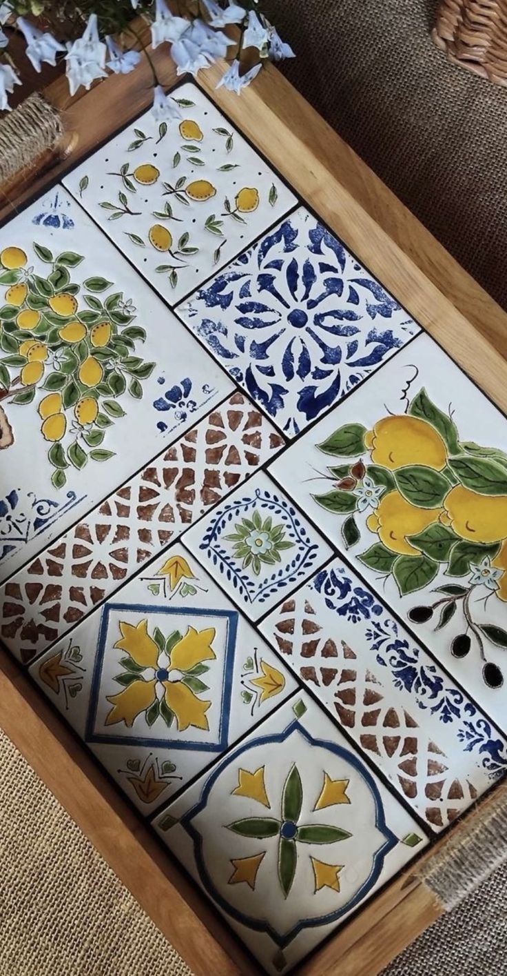 a close up of a tray on a couch with flowers and leaves painted on it