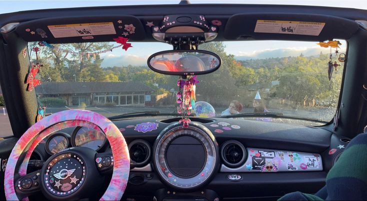 the interior of a car with steering wheel covers decorated in pink and purple flowers, on display