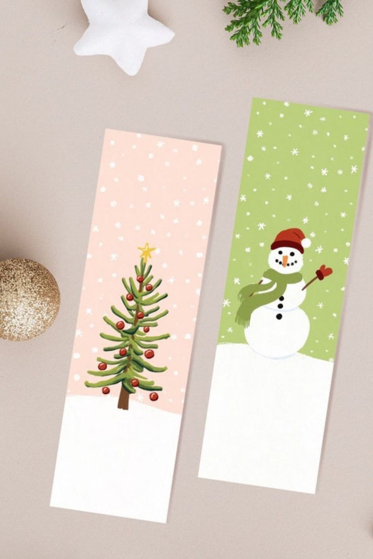 two christmas bookmarks sitting on top of a table