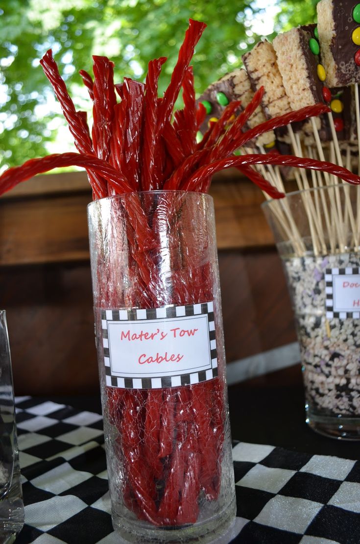 candy sticks are in a glass vase on a table