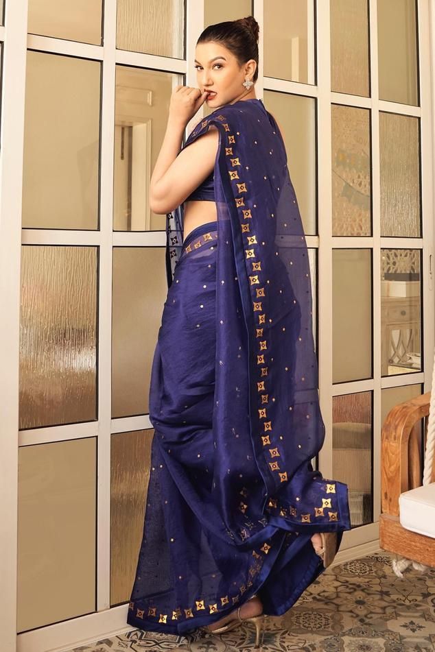 Ink blue saree in silk organza base with all over floral aari embroidery with sequins and zari. Paired with halter neck sleeveless blouse and a petticoat.
Components: 3
Pattern: Embroidery
Type Of Work: Aari Work With Sequins and Zari
Neckline: Halter Neck
Sleeve Type: Sleeveless
Fabric: Saree: Silk Organza, Blouse: Chanderi, Petticoat: Poly Satin
Color: Blue
Other Details: 
Length:
Saree: 5.6-5.75inches
Petticoat: 39inches
Occasion: Wedding, Puja - Aza Fashions Blue Raw Silk Pre-draped Saree For Festivals, Blue Raw Silk Saree With Unstitched Blouse, Festive Blue Tussar Silk Pre-draped Saree, Blue Semi-stitched Chanderi Saree, Blue Unstitched Tussar Silk Blouse Piece, Semi-stitched Blue Chanderi Saree, Blue Chanderi Saree With Embroidery, Blue Chanderi Saree With Traditional Drape, Designer Blue Organza Pre-draped Saree