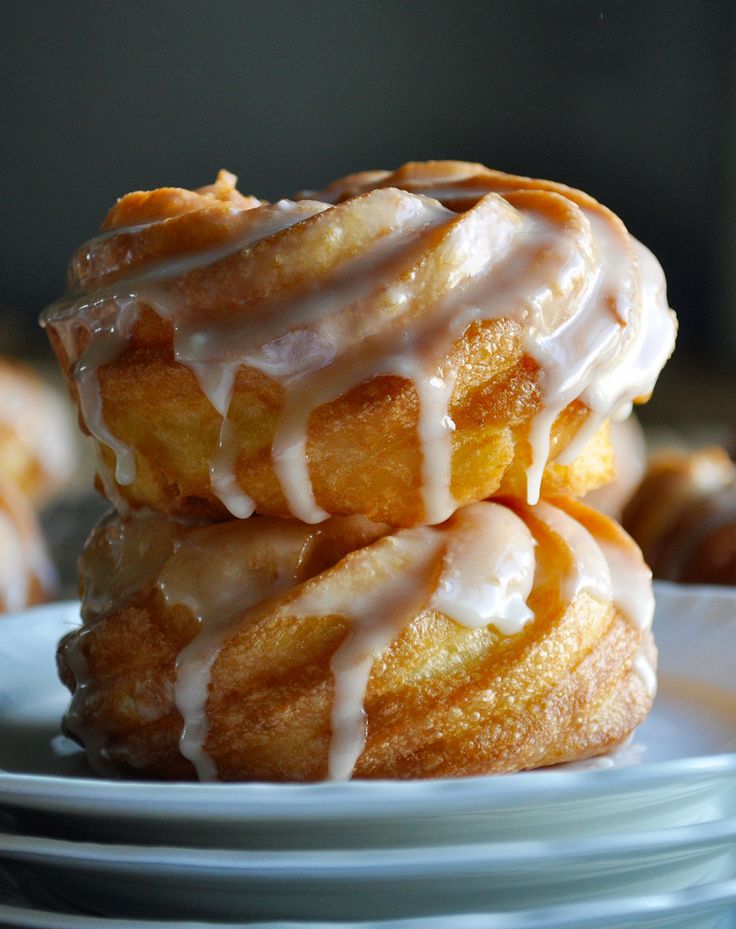 three donuts stacked on top of each other with icing drizzled on them