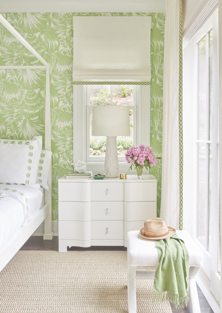 a bedroom with green wallpaper and white furniture