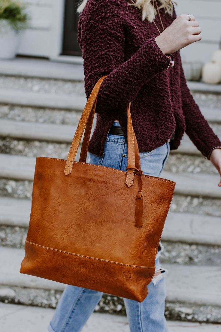 Beautiful. That’s what you call this large saddle tan leather tote bag. The large size is just right, whether you’re carrying a laptop or your favorite pen and journal. The full grain leather with minimalistic design is lightweight for its size. The handmade stitching details make it a fun addition to any outfit — for travel, work, or play. Brown Bags For Fall, Brown Smooth Grain Bags For Fall, Classic Saddle Shoulder Bag For Everyday, Everyday Saddle Bags With Leather Handles, Brown Saddle Shoulder Bag With Smooth Grain, Brown Smooth Grain Saddle Shoulder Bag, Fall Smooth Grain Tote Shoulder Bag, Everyday Saddle Satchel With Leather Handles, Everyday Saddle Bag In Soft Leather