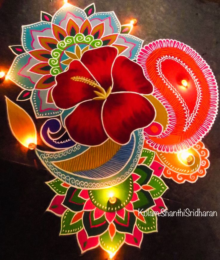 an intricately decorated diya with lights and flowers on the floor in front of it