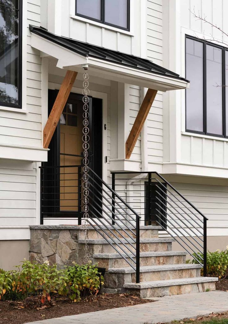 a white house with black railing and stairs