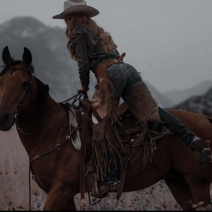 a woman riding on the back of a brown horse