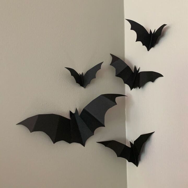 several black bats are hanging on the wall