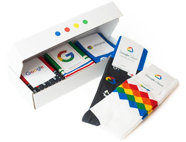 an open box with several different colored socks in it's lid and inside the box is a google logo