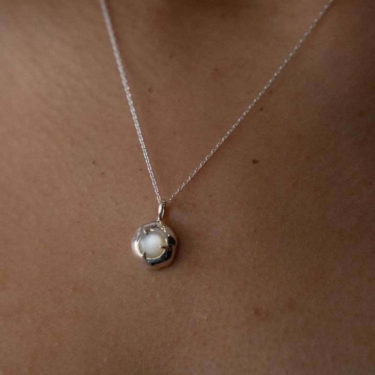 Embrace the gentle healing power of the sea with the soothing energy of Mother of Pearl. Our Keeper Necklace is crafted to hold its essence close to your heart, offering a constant source of comfort and serenity. Nestled delicately within the organically shaped three-pronged Keeper pendant, the Mother of Pearl radiates its tranquil aura. Technically known as "nacre," this crystallized mineral compound forms on the inner shell layer of select mollusks. Saltwater oysters, abalone, and freshwater m Sterling Silver Necklaces With Moon Charm For Meditation, Nature-inspired White Necklaces For Healing, White Nature-inspired Necklaces For Healing, Elegant Round Pendant Charm Necklaces For Healing, Delicate Sterling Silver Keepsake Necklace, Ethereal Sterling Silver Pendant Necklace, Ethereal Pendant Necklace For Gifts, Elegant Round Pendant Charm Necklace For Healing, Ethereal Necklace With Moon Charm For Gifting