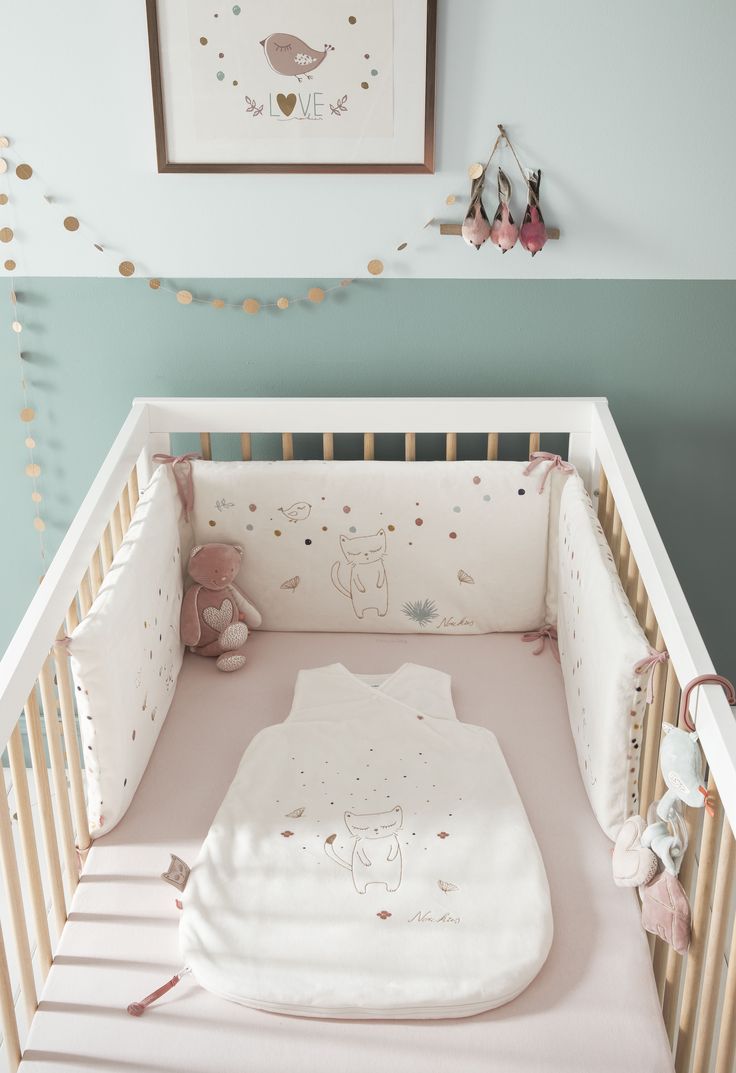 a baby's crib with a teddy bear in it