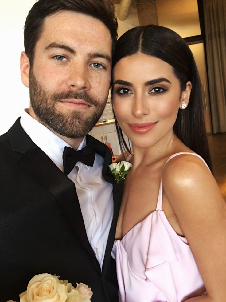 a man in a tuxedo standing next to a woman