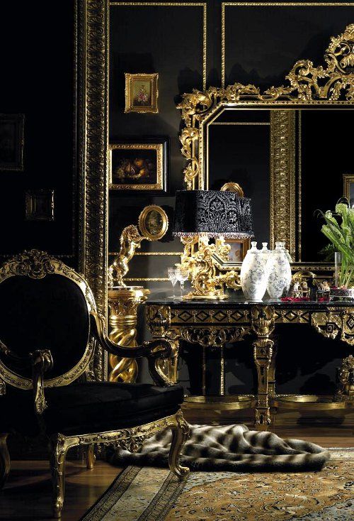 an ornately decorated room with black walls and gold trimmings on the mirror