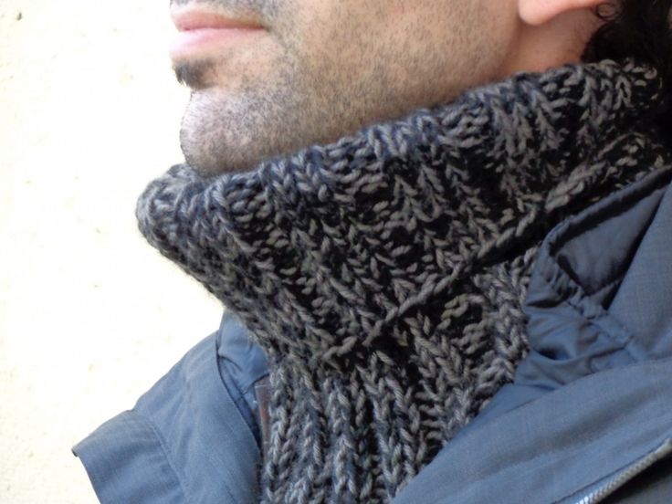 a close up of a person wearing a jacket and scarf with a cell phone in his hand