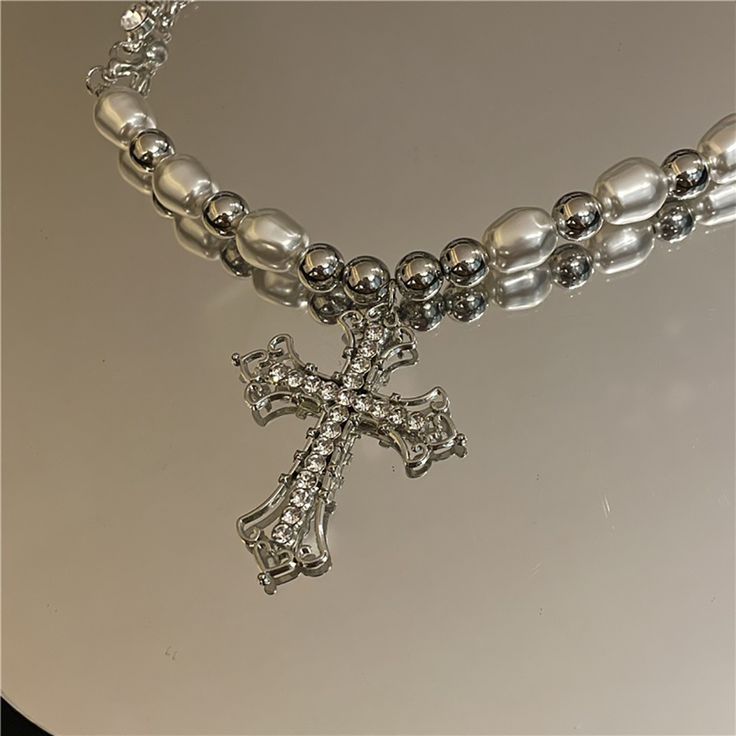 Consists of pearls and a cross. It provides a lasting memento, whether it's first communion, a birthday or any special occasion. If you're looking for a pearl necklace that you'll love, you won't want to miss this pearl cross necklace. When you wear a simple t-shirt and put on this Pearl Cross Necklace, you will find that you instantly get a whole new look. That being the case, this pearl cross necklace is friendly to T-shirt lovers and those who don't want to spend more time deciding which outf Baroque Jewelry, Pearl Cross Necklace, Goth Necklace, Silver Cross Necklace, Neck Jewelry, Y2k Jewelry, Style Baroque, Gothic Necklace, Neck Jewellery