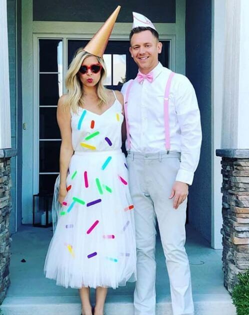 a man and woman dressed up for a birthday party with confetti on their hats