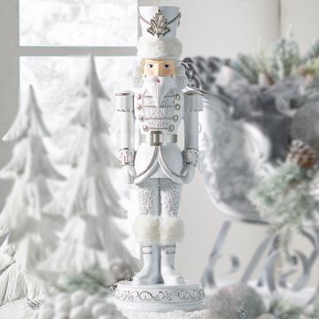 a nutcracker figurine sitting on top of a table next to christmas trees