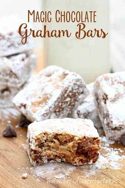 chocolate graham bars are stacked on top of each other with powdered sugar around them