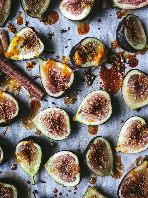 sliced figs on a baking sheet with spices and seasoning next to them, ready to be eaten