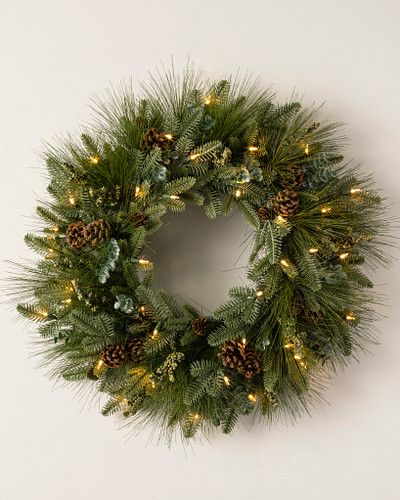 a christmas wreath with pine cones and lights