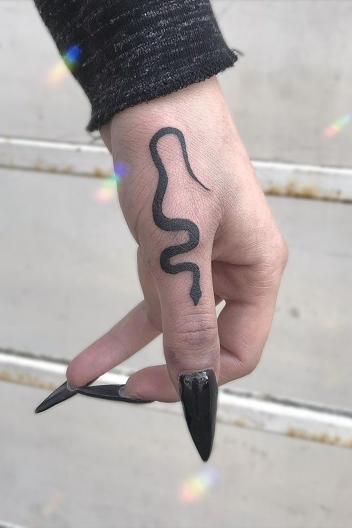 a person's hand with a snake tattoo on it