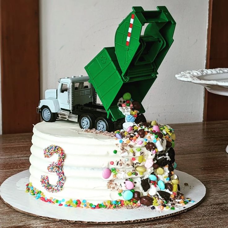 a birthday cake with a dump truck on top and sprinkles all over it