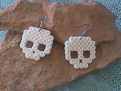 a pair of earrings made out of buttons sitting on top of a piece of rock