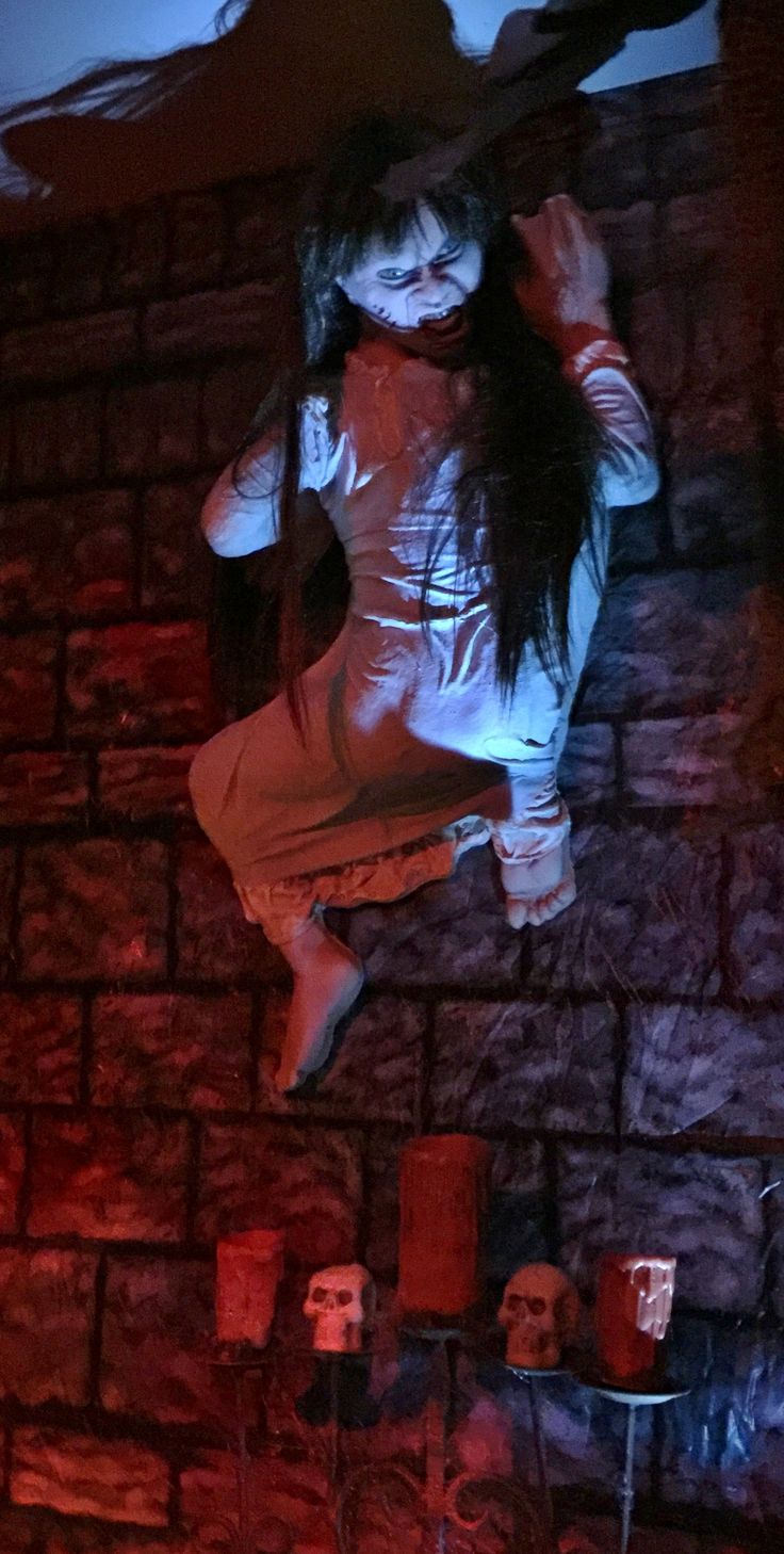 a woman in white dress standing on brick wall next to fire hydrant and candles