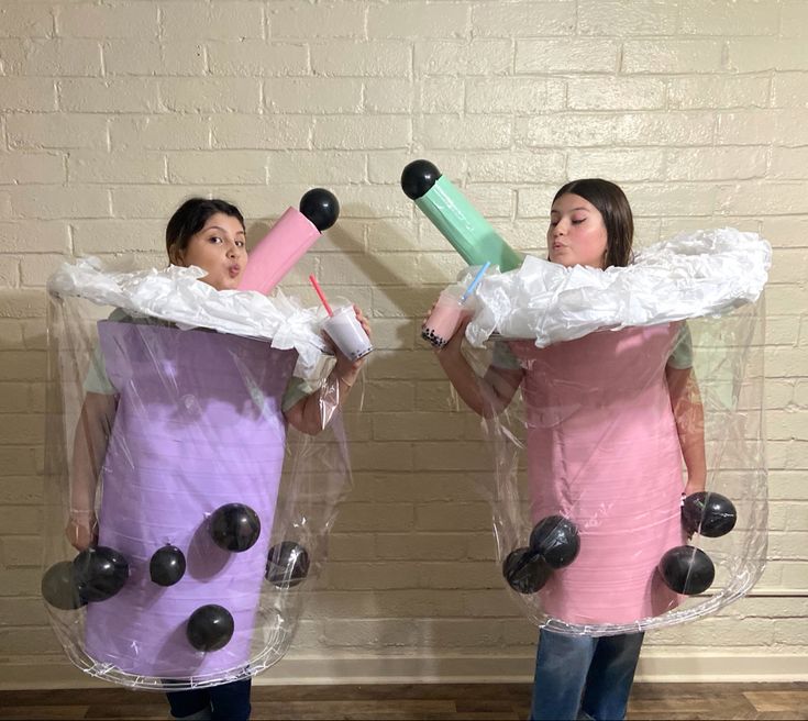 two women dressed in costumes made to look like they are holding toothbrushes and tubes