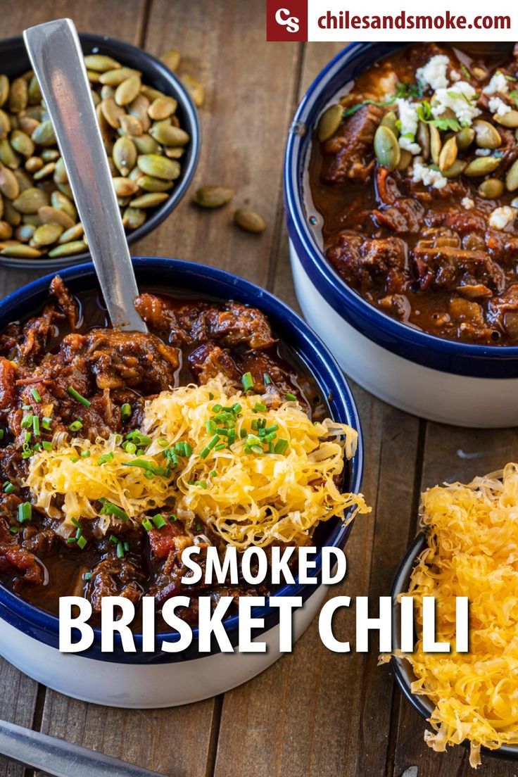 three bowls filled with chili, beans and other food on a wooden table next to utensils