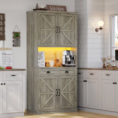 a kitchen with white cabinets and wooden floors