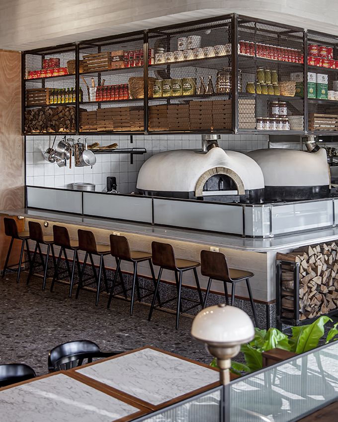 the interior of a restaurant with tables, chairs and an oven in the back wall