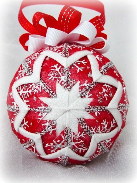 a red and white ornament with snowflakes on it's side